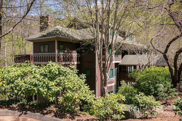 81 Creekside Way Unit F/101, Burnsville, NC 28714 - view of front of house with a chimney, a shingled roof, and a balcony