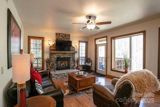 81 Creekside Way Unit F/101, Burnsville, NC 28714 - living area with a stone fireplace, a ceiling fan, wood finished floors, and baseboards
