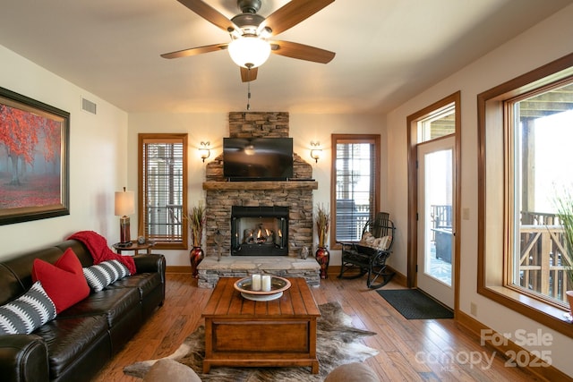 81 Creekside Way Unit F/101, Burnsville, NC 28714 - living area featuring a stone fireplace, wood-type flooring, and baseboards