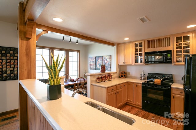 81 Creekside Way Unit F/101, Burnsville, NC 28714 - kitchen featuring black appliances, wood finished floors, a peninsula, light countertops, and glass insert cabinets