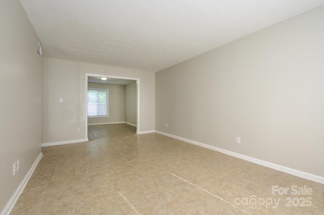 unfurnished room with baseboards