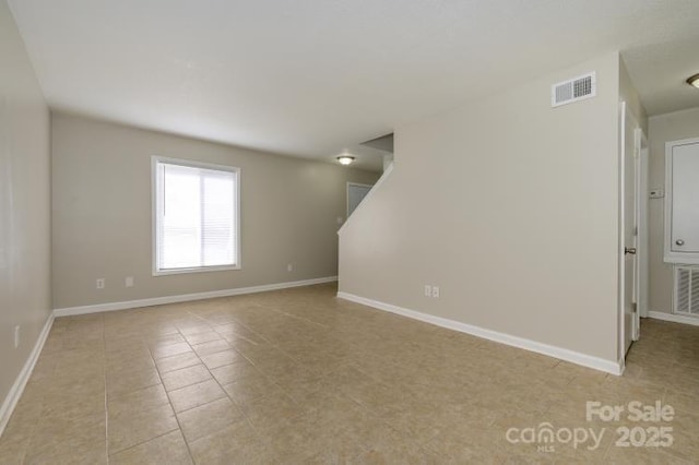 unfurnished room with light tile patterned floors and baseboards