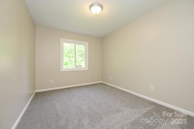 unfurnished room featuring carpet floors and baseboards
