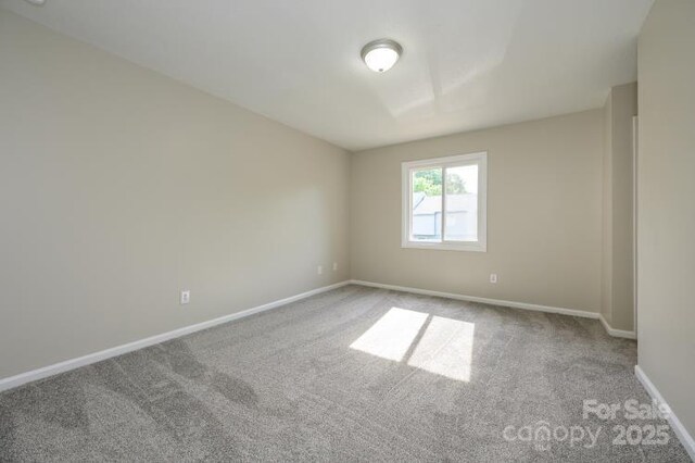 carpeted empty room with baseboards