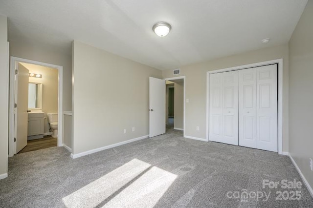 unfurnished bedroom featuring carpet, a closet, baseboards, and connected bathroom