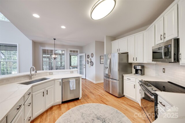 kitchen with appliances with stainless steel finishes, a sink, white cabinetry, and recessed lighting