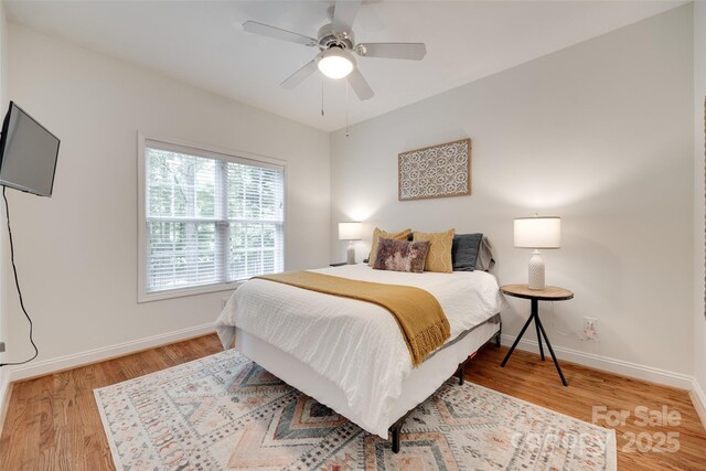 bedroom featuring wood finished floors, baseboards, and a ceiling fan
