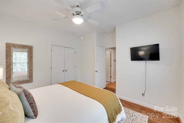 bedroom featuring light wood-style floors, baseboards, ceiling fan, and a closet
