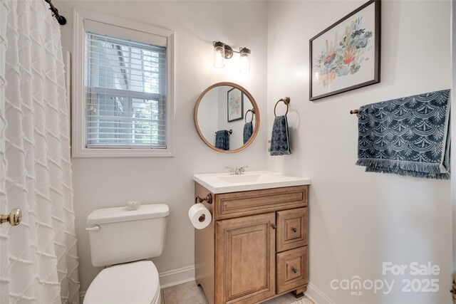 bathroom with baseboards, toilet, vanity, and a shower with shower curtain
