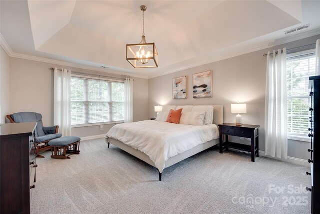 carpeted bedroom featuring a raised ceiling, a chandelier, crown molding, and multiple windows