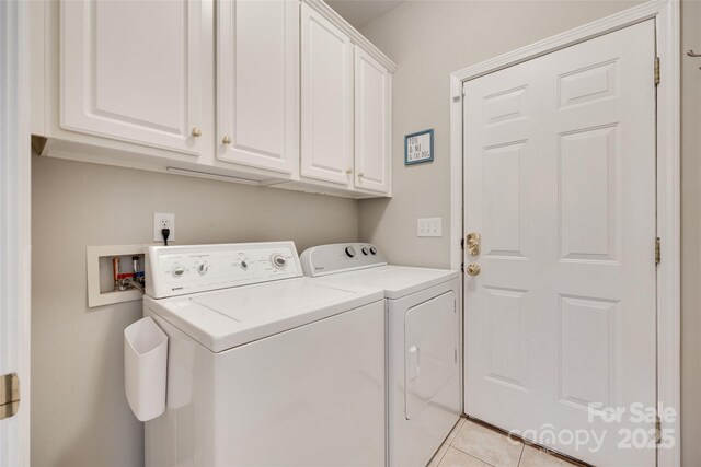 laundry room featuring cabinet space, washer and dryer, and light tile patterned floors