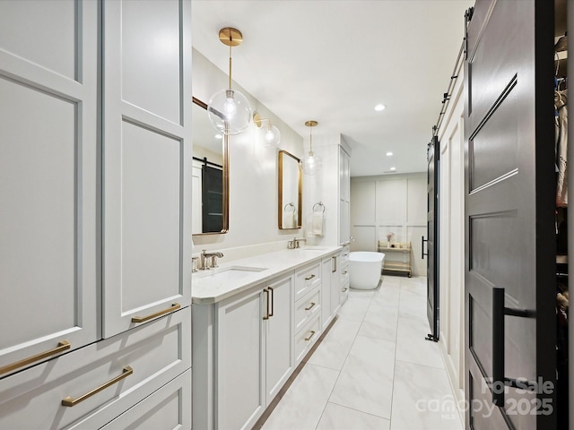 bathroom with double vanity, a freestanding bath, recessed lighting, and marble finish floors