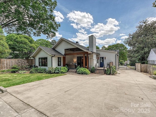 view of front of home with a gate, a chimney, and a deck