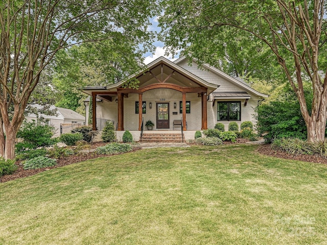 view of front of property featuring brick siding and covered porch