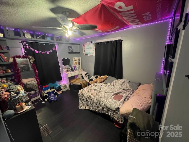 bedroom featuring wood finished floors, ceiling fan, and a textured ceiling