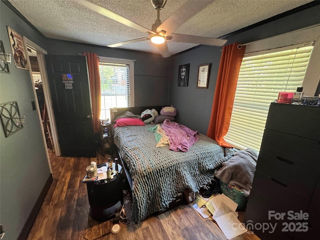 bedroom featuring wood finished floors, a textured ceiling, and a ceiling fan