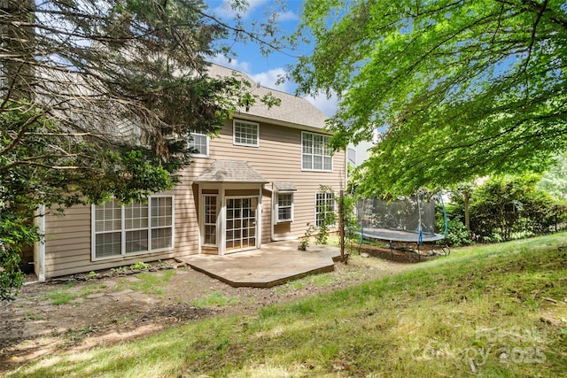6434 Skyline Dr, Charlotte, NC 28269 - back of property with a trampoline, a patio area, and a yard