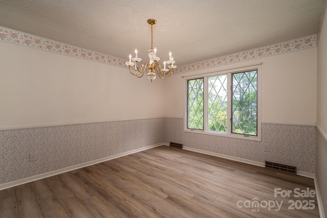 104 Ridge Dr, Stanley, NC 28164 - unfurnished room with wainscoting, wallpapered walls, wood finished floors, a chandelier, and baseboards