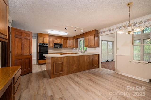 104 Ridge Dr, Stanley, NC 28164 - kitchen featuring black appliances, brown cabinets, light countertops, light wood-type flooring, and a textured ceiling