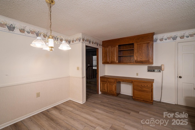 104 Ridge Dr, Stanley, NC 28164 - kitchen featuring brown cabinets, open shelves, wainscoting, light wood-style flooring, and a textured ceiling