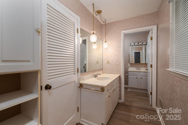 104 Ridge Dr, Stanley, NC 28164 - bathroom featuring wood finished floors, two vanities, and a textured ceiling