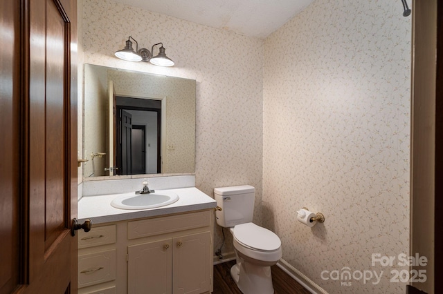 104 Ridge Dr, Stanley, NC 28164 - half bathroom featuring wallpapered walls, toilet, wood finished floors, and vanity