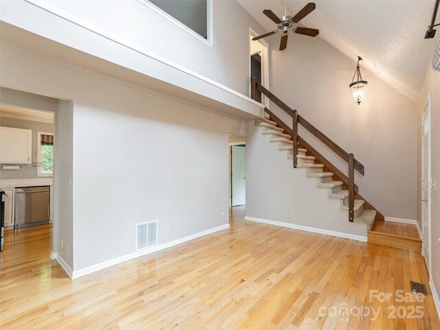 55 Willow Bnd, Hendersonville, NC 28792 - unfurnished living room featuring stairway, ceiling fan, light wood-type flooring, high vaulted ceiling, and baseboards