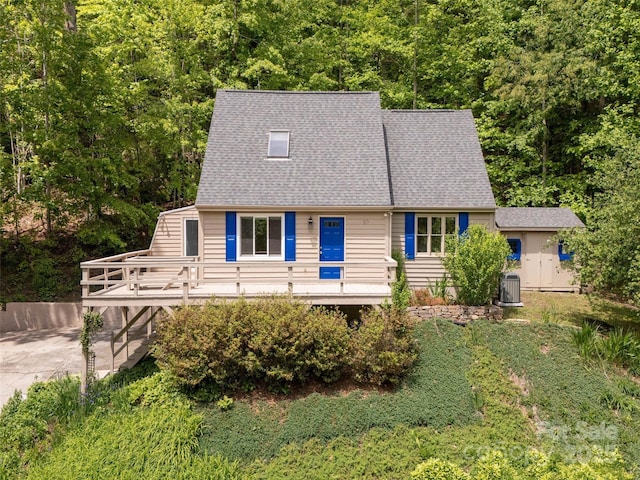55 Willow Bnd, Hendersonville, NC 28792 - view of front of property with driveway, central air condition unit, a shingled roof, a deck, and a view of trees