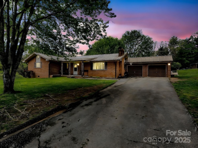 single story home featuring brick siding, an attached garage, a chimney, and driveway