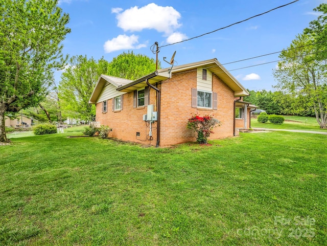view of home's exterior with a yard and brick siding