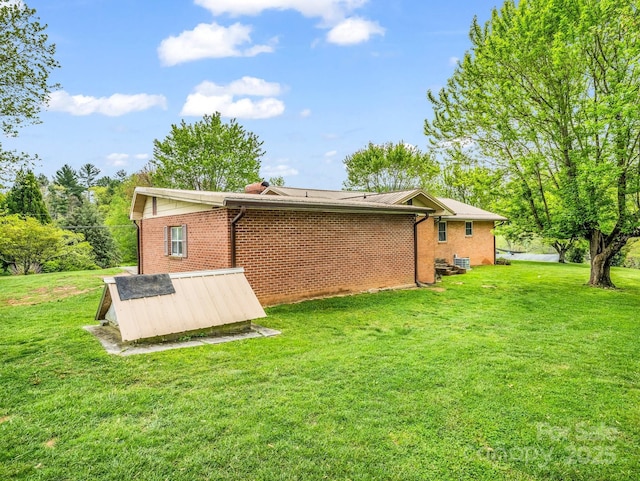 back of house featuring a yard and brick siding