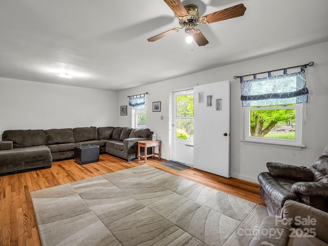 living area with wood finished floors and ceiling fan