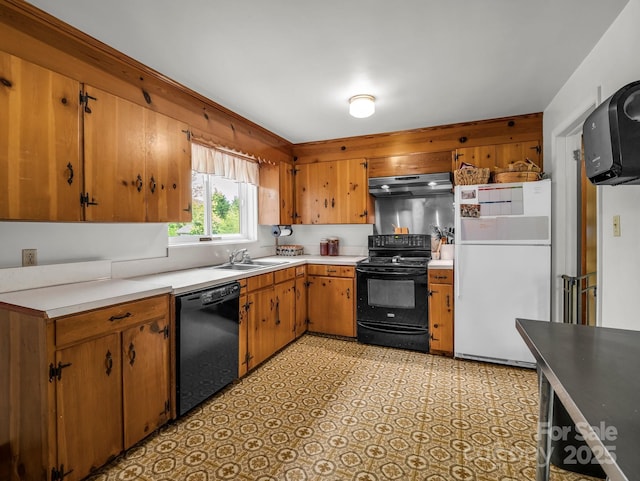 kitchen featuring black appliances, under cabinet range hood, a sink, light countertops, and brown cabinets