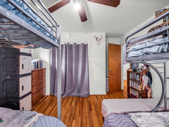 bedroom with wood finished floors, ceiling fan, and baseboards