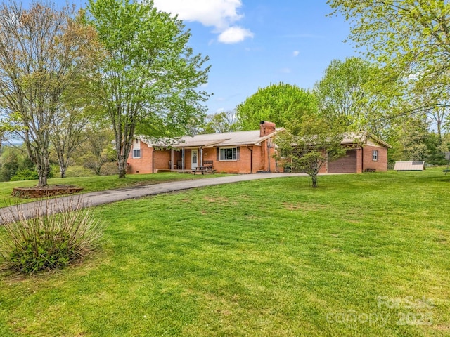 ranch-style home with driveway, brick siding, a chimney, a garage, and a front yard