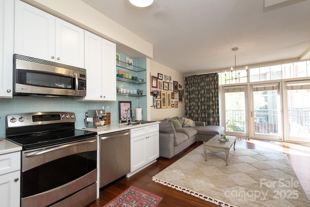 1320 Fillmore Ave Unit 426, Charlotte, NC 28203 - kitchen with stainless steel appliances, a sink, tasteful backsplash, dark wood-style flooring, and light countertops