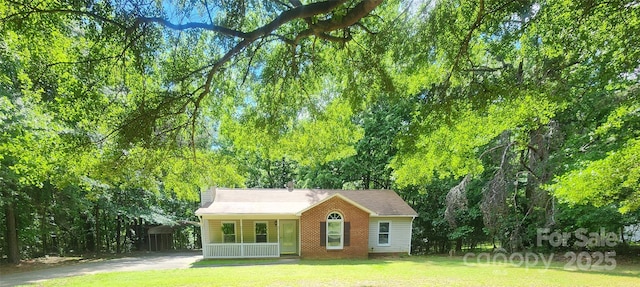4409 Homestead Rd, Rock Hill, SC 29732 - rear view of house featuring concrete driveway, a yard, covered porch, and brick siding
