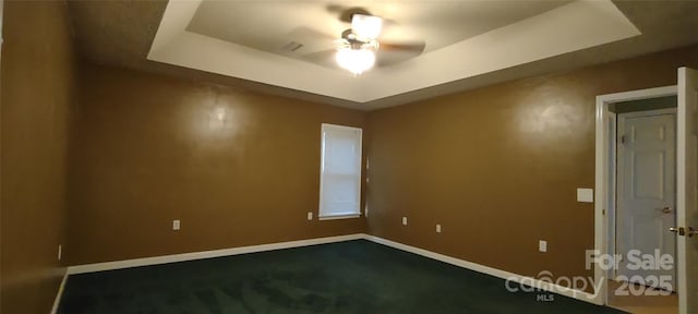 4409 Homestead Rd, Rock Hill, SC 29732 - empty room with a tray ceiling, dark carpet, baseboards, and ceiling fan