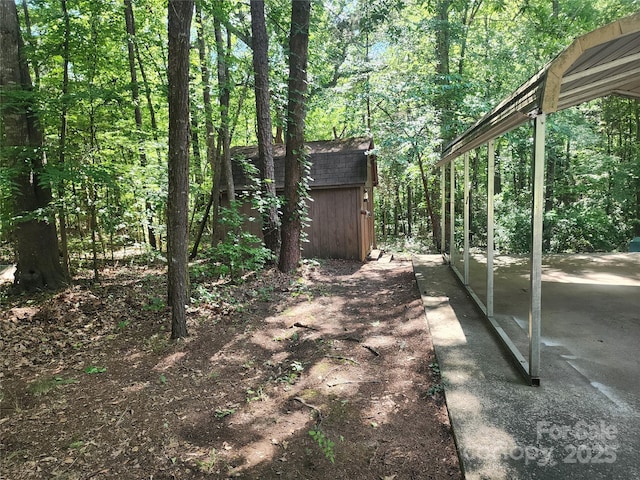 4409 Homestead Rd, Rock Hill, SC 29732 - view of yard featuring a shed, a forest view, an outdoor structure, and a patio