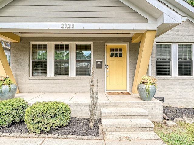 entrance to property with brick siding and covered porch