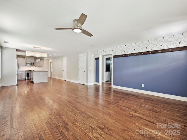 unfurnished living room with ceiling fan, dark wood-style flooring, and baseboards