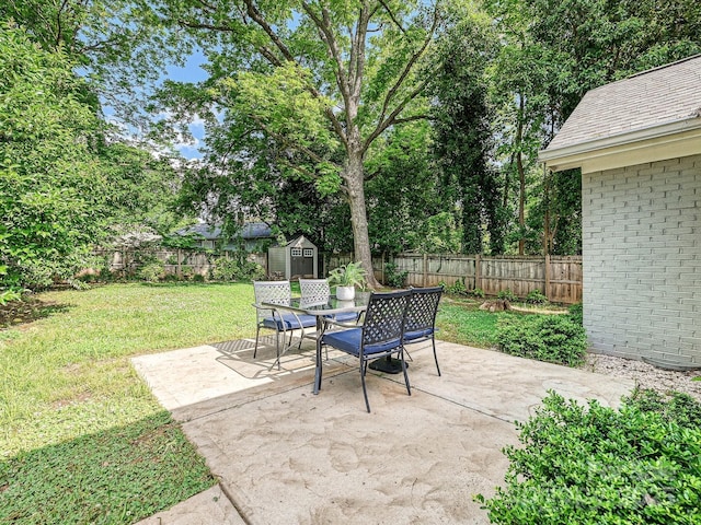 view of patio featuring a storage shed, an outdoor structure, and outdoor dining area