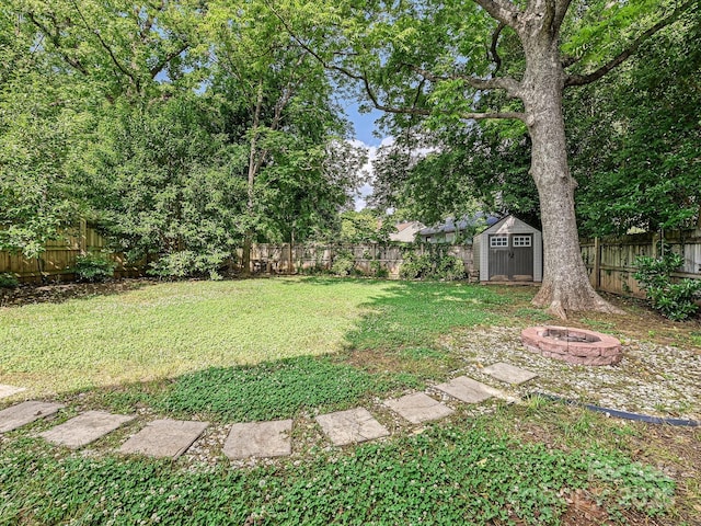 view of yard featuring an outdoor fire pit, a storage shed, and an outdoor structure
