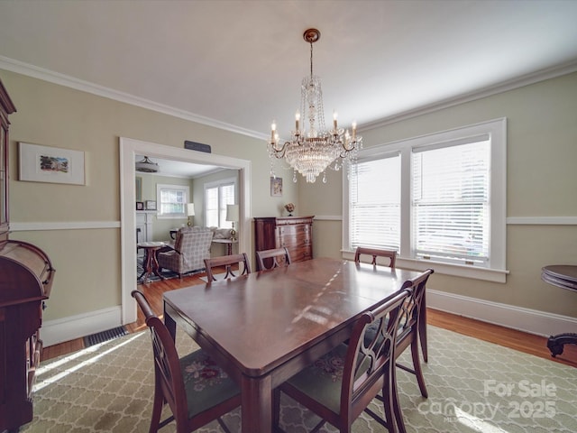 907 Edgewood Cir, Gastonia, NC 28052 - dining space featuring wood finished floors, ornamental molding, a chandelier, and baseboards