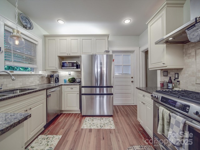 907 Edgewood Cir, Gastonia, NC 28052 - kitchen featuring appliances with stainless steel finishes, a sink, backsplash, wall chimney exhaust hood, and dark stone countertops