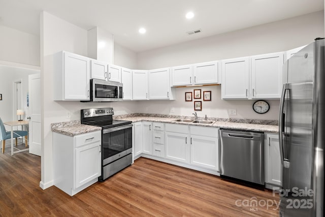31 Cherry Laurel Ln, Swannanoa, NC 28778 - kitchen featuring a sink, wood finished floors, light stone counters, visible vents, and appliances with stainless steel finishes