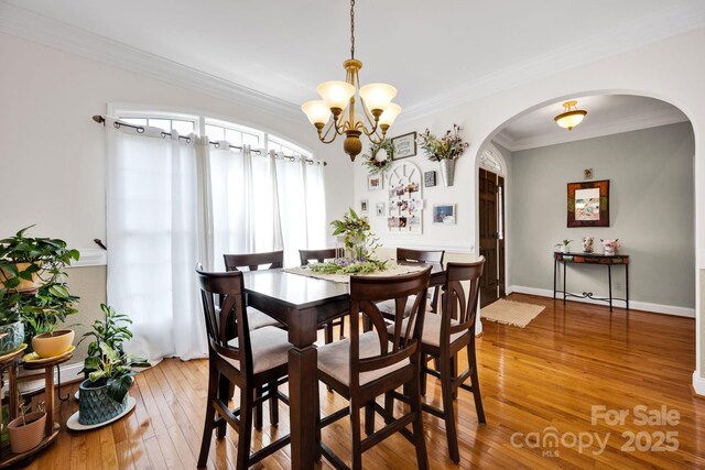3610 Providence Mill Rd, Maiden, NC 28650 - dining space with arched walkways, light wood-type flooring, crown molding, and a chandelier