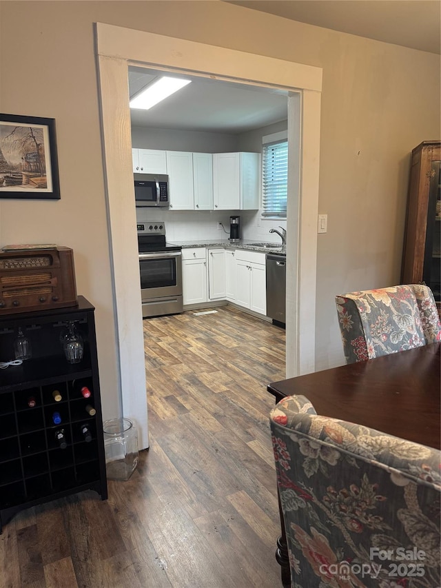 247 E Cabarrus Ave, Concord, NC 28025 - kitchen featuring stainless steel appliances, dark wood finished floors, white cabinets, and light countertops