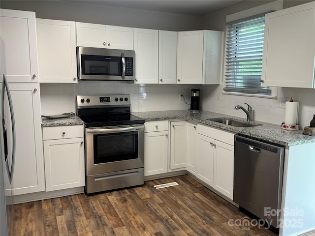 247 E Cabarrus Ave, Concord, NC 28025 - kitchen with stainless steel appliances, white cabinetry, backsplash, light stone counters, and dark wood-style flooring