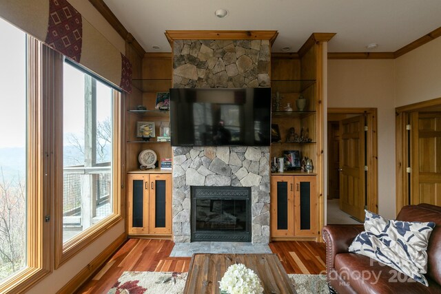 140 Slickrock Rd Unit F3, Burnsville, NC 28714 - living room featuring a stone fireplace, a wealth of natural light, crown molding, and wood finished floors